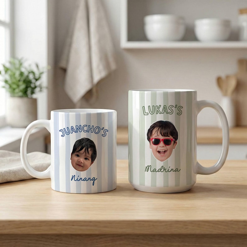 Puede incluir: Dos tazas de cer&aacute;mica con rayas verticales. La taza izquierda tiene rayas azules, una foto de un ni&ntilde;o y el texto "JUANCHO'S Ninang". La taza derecha tiene rayas verdes, una foto de un ni&ntilde;o con gafas de sol rojas y el texto "LUKAS'S Madrina".