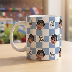 以下が含まれることがあります： 水色と白のチェック柄が施された白いセラミック製のマグカップ。マグカップには、幼い子供の円形のポートレートが繰り返し配置されており、ダークカラーの丸みを帯びた手書き風フォントで「best dad ever」というテキストがプリントされています。