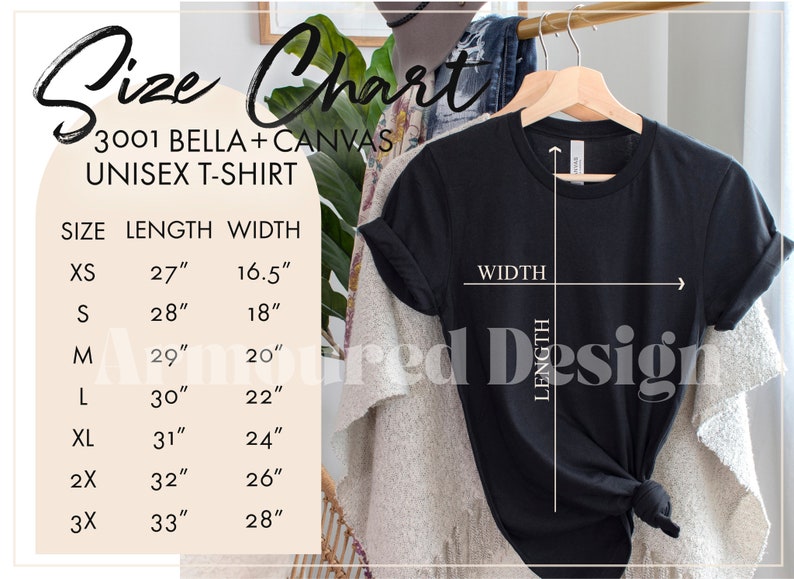 K&ouml;nnte beinhalten: Schwarzes Unisex-T-Shirt, das an einem Holzb&uuml;gel h&auml;ngt, mit einer Gr&ouml;&szlig;entabelle. Die Tabelle listet die Gr&ouml;&szlig;en XS bis 3X auf, mit L&auml;ngen von 68,6 cm bis 83,8 cm und Breiten von 41,9 cm bis 71,1 cm. Der Text "3001 BELLA+CANVAS UNISEX T-SHIRT" ist ebenfalls sichtbar.