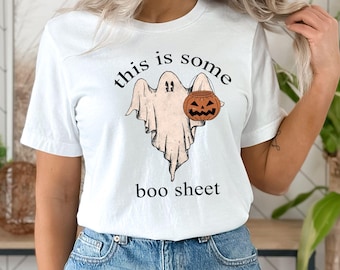 May include: White t-shirt with a ghost holding a jack-o-lantern and the text "this is some boo sheet"