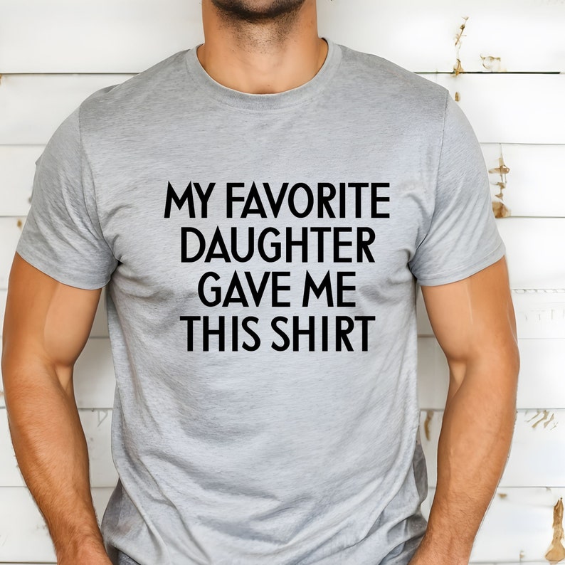 May include: A grey t-shirt with the text "My favourite daughter gave me this shirt" printed in black.