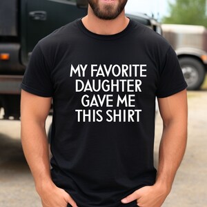 May include: A black t-shirt with white text that reads "My favourite daughter gave me this shirt."