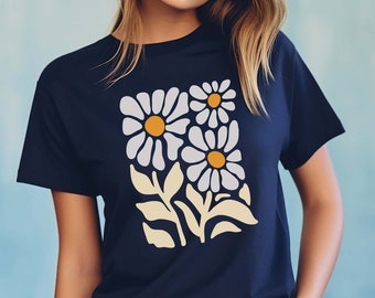 May include: A navy blue t-shirt with a white daisy floral print. The daisies have yellow centers and are arranged in a cluster with green stems and leaves.