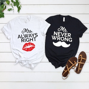 May include: Two white t-shirts with black text and graphics. One shirt says "Mrs. Always Right" with a red lip print. The other shirt says "Mr. Never Wrong" with a white mustache graphic.