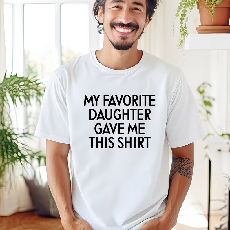 May include: White t-shirt with black text that reads "My favourite daughter gave me this shirt."