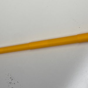 May include: A yellow telescopic pole, approximately 48 inches long, made of plastic. The pole is fully extended and appears to be made of two sections that slide together.