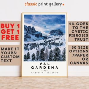 Könnte beinhalten: Ein gerahmter Druck mit einer schneebedeckten Berglandschaft und dem Text "VAL GARDENA ITALY" sowie Koordinaten. Der Druck hat einen goldenen Rahmen und den Text "classic print gallery" oben. Zusätzlicher Text lautet "BUY 1 GET 1 FREE" und "MAKE IT YOURS: CUSTOM TEXT".