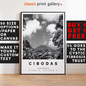 May include: Black and white Cibodas, Indonesia landscape print. The print features a mountain scene with text that reads "CIBODAS" and coordinates. The print is framed in a black frame. The image also includes text that reads "50 SIZE OPTIONS/PAPER OR CANVAS" and "MAKE IT YOURS: CUSTOM TEXT".