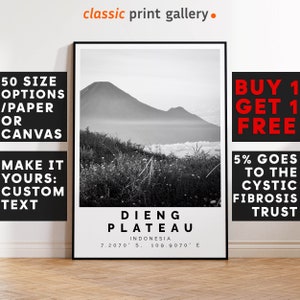 Op de afbeelding: Zwart-wit ingelijste print van het Dieng Plateau in Indonesië. De landschapsfoto toont een bergketen en gras op de voorgrond. De print bevat de tekst "DIENG PLATEAU INDONESIA" met coördinaten. De print is van de "classic print gallery".