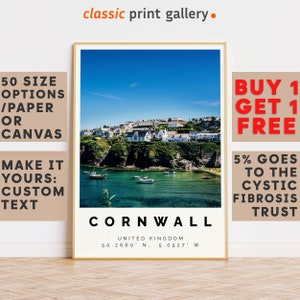 May include: A framed print featuring a coastal scene of Cornwall, United Kingdom, with a clear blue sky and turquoise water. The print includes the text "Cornwall" and coordinates, with additional text indicating size options and customization.