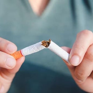 May include: A person is breaking a cigarette in half, signifying quitting smoking.