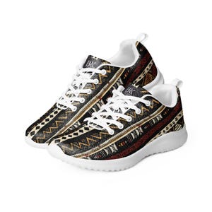 May include: White sneakers with a black, brown, and red geometric pattern. The pattern is reminiscent of traditional African textiles.