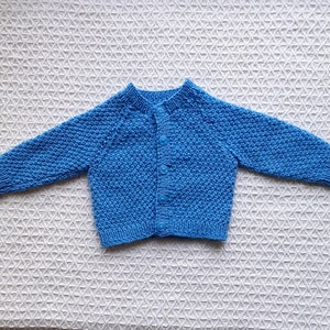Cute Blue Cardigan in a Striking Moss Stitch. For age 6-9 months old.