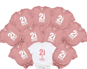 May include: Nine pink t-shirts with the text "21 SQUAD" and a bottle graphic. One white t-shirt with the text "21 & LEGAL" and a bottle graphic.