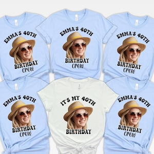May include: A collection of light blue and white t-shirts. Each shirt features a photo of a woman wearing a hat and sunglasses, with the text "EMMA'S 40TH BIRTHDAY CREW" or "IT'S MY 40TH BIRTHDAY".
