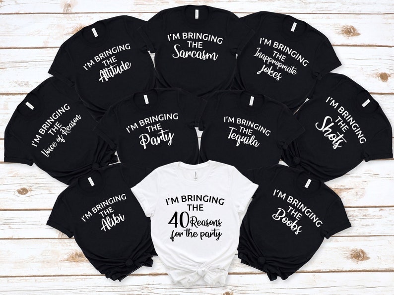 Puede incluir: Una colecci&oacute;n de camisetas negras y blancas con frases divertidas impresas, como "I'M BRINGING THE Attitude", "I'M BRINGING THE Sarcasm" y "I'M BRINGING THE 40 Reasons for the party".