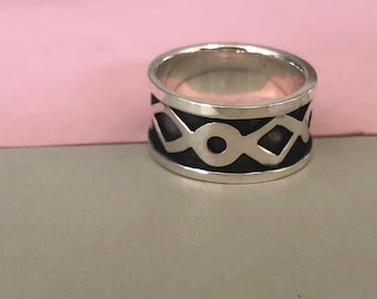 Ring made of blackened silver with a hammer finish and an unusual pattern of diamonds and circles