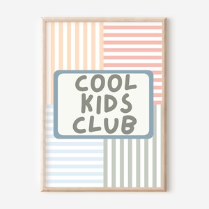 May include: A framed print with a light blue, gray, and white striped background. The print features a light blue rectangle with the text "COOL KIDS CLUB" in gray.