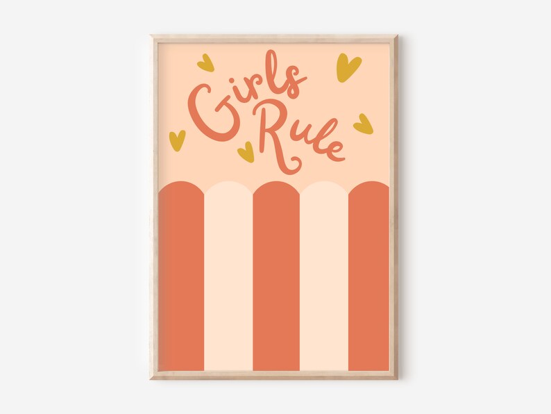 May include: A peach-coloured poster with the text "Girls Rule" in pink script. The poster has a striped pattern of peach and orange and is surrounded by small gold hearts.
