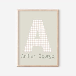 May include: A framed print with a light green background featuring a large white letter "A" with a beige gingham pattern. The name "Arthur George" is printed in grey below the letter.