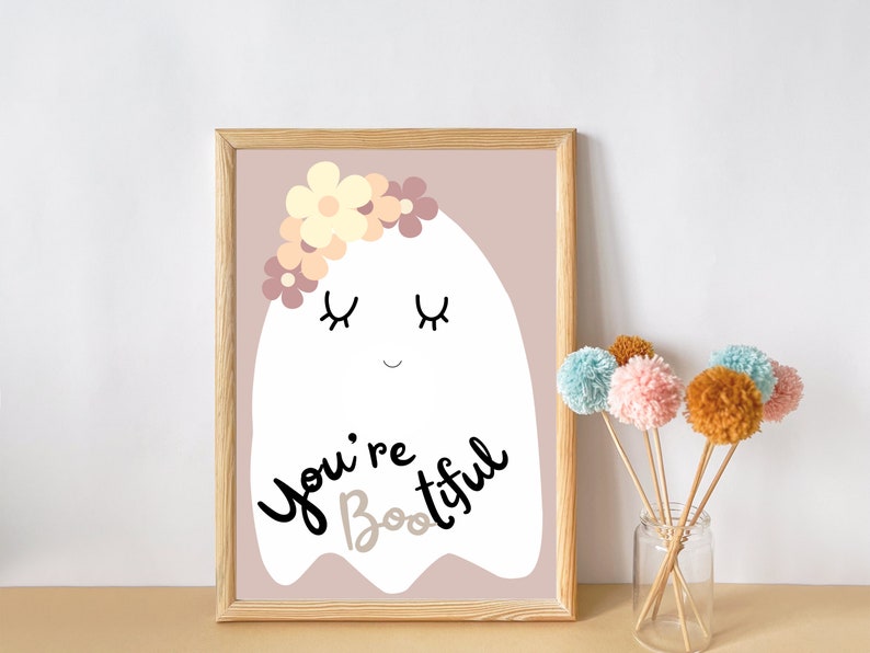 May include: A white ghost with a flower crown and closed eyes, on a light pink background. The ghost says "You're Boo-tiful".