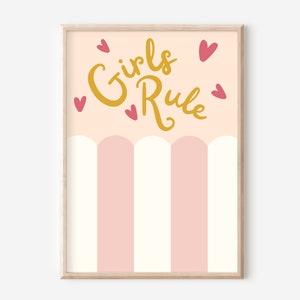 Pu&ograve; includere: Stampa artistica incorniciata con la scritta dorata "Girls Rule", accompagnata da cuori rosa. La met&agrave; inferiore presenta strisce verticali rosa e bianche alternate, su uno sfondo color pesca chiaro.