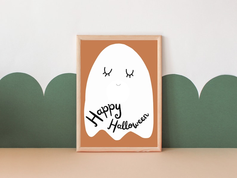 May include: A framed print with a white ghost illustration and the text "Happy Halloween" on a brown background.