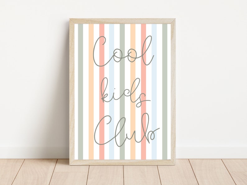 May include: A framed print with a striped background in shades of peach, light blue, and green. The text "Cool kids club" is written in a cursive font in gray.