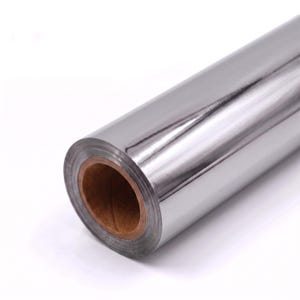 May include: A roll of reflective silver metallic film featuring a smooth, mirror-like surface finish. The material is wound tightly around a cylindrical brown cardboard core, showing a high-gloss sheen that reflects light across its entire length.