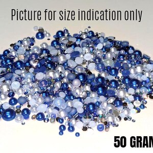 May include: A close-up of a pile of blue and white pearl beads, with a white background and the text "50 GRAMS" at the bottom.