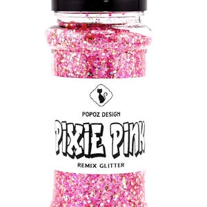 May include: A clear plastic shaker bottle filled with vibrant pink glitter. The label features a black cat icon, the text POPOZ DESIGN, PIXIE PINK, and REMIX GLITTER. The bottle is topped with a black screw-on cap with a flip-top dispensing lid.
