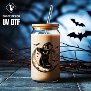 May include: A clear glass tumbler with a bamboo lid and a glass straw. The tumbler features a black cat wearing a witch hat, sitting on a crescent moon, with the text "Child of the Night". The background has bats and a blue night sky.
