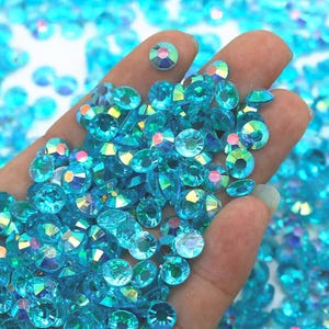May include: A large pile of turquoise iridescent rhinestones, perfect for crafting and jewelry making.