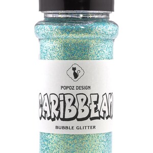 May include: A clear plastic bottle filled with Caribbean Bubble Glitter. The bottle has a black lid and a white label with the text "CARIBBEAN" and "BUBBLE GLITTER". The glitter is a mix of blue and gold.