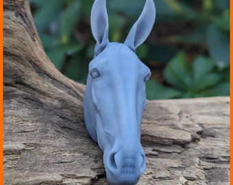 Peut inclure: Une sculpture de tête de cheval en trois dimensions, de couleur gris clair, dotée d'oreilles dressées, de contours faciaux définis et d'une finition mate lisse. La tête équine présente des détails anatomiques réalistes, dont les narines.