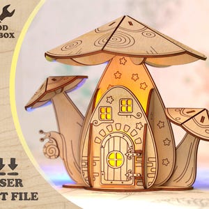 May include: A laser-cut wooden fairy house in a mushroom design. The house has a door, windows, and star cutouts, with snail and mushroom accents. The text "WOOD TOOLBOX" and "LASER CUT FILE" are visible.
