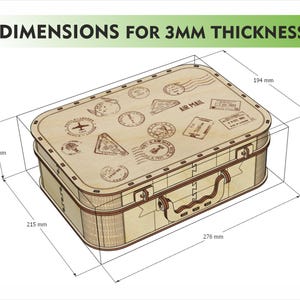 Puede incluir: Una maleta de madera con sellos de tem&aacute;tica de viaje y el texto "AIR MAIL". Las dimensiones son 27,6 cm de largo, 21,5 cm de ancho y 9 cm de alto. El grosor es de 3 mm. La maleta tiene un asa y cierres met&aacute;licos.
