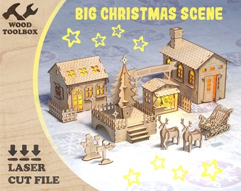 May include: A laser-cut wooden Christmas scene featuring houses, a bridge, a Christmas tree, reindeer, a sleigh, and a snowman. The scene includes the text "BIG CHRISTMAS SCENE" and "MERRY CHRISTMAS". The Wood Toolbox logo is visible.