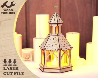 May include: A wooden laser cut church-shaped lantern with a cross on top. The lantern has a small window on each side and a larger window on the front. The lantern is lit from within, creating a warm glow. The lantern is sitting on a table with other candles.