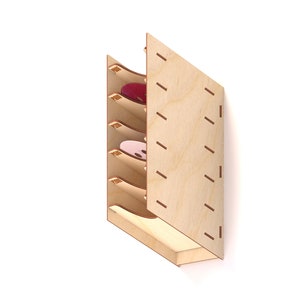 Puede incluir: Un estante de pared de madera con cinco estantes para guardar objetos redondos. Los estantes est&aacute;n hechos de madera contrachapada y tienen un acabado de madera natural. El estante est&aacute; dise&ntilde;ado para guardar objetos como posavasos, tapas de botellas u otros objetos redondos peque&ntilde;os.