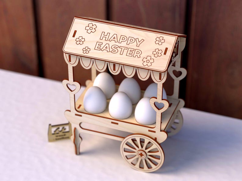 May include: A wooden Easter egg stand with a sign that reads "Happy Easter". The stand has a white painted finish and is decorated with hearts and flowers. It holds six white eggs.