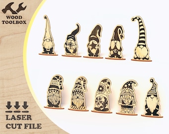 May include: Set of 10 laser cut wooden gnome ornaments. The gnomes are in various poses and designs, including a gnome with a star, a gnome with a present, and a gnome with a snowflake. The gnomes are all black and white.