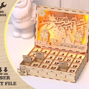 May include: A wooden advent calendar with a laser-cut Christmas scene featuring houses, trees, and Santa's sleigh. The calendar has 24 numbered compartments with small hinged doors. The text "WOOD TOOLBOX" and "LASER CUT FILE" are visible.