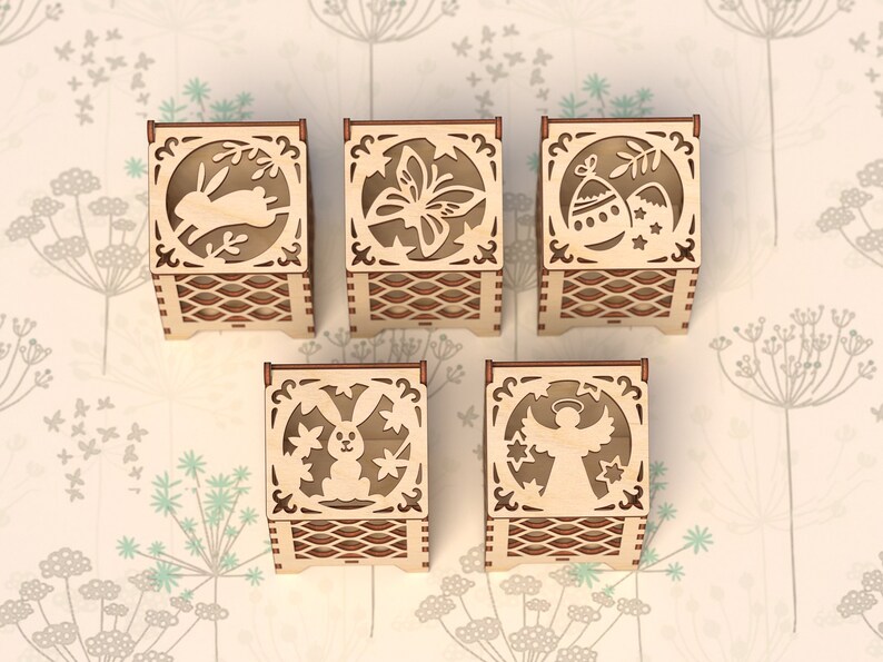 May include: Set of six wooden boxes with intricate laser-cut designs. Each box features a different Easter-themed image, including a bunny, butterfly, eggs, a chick, and an angel.