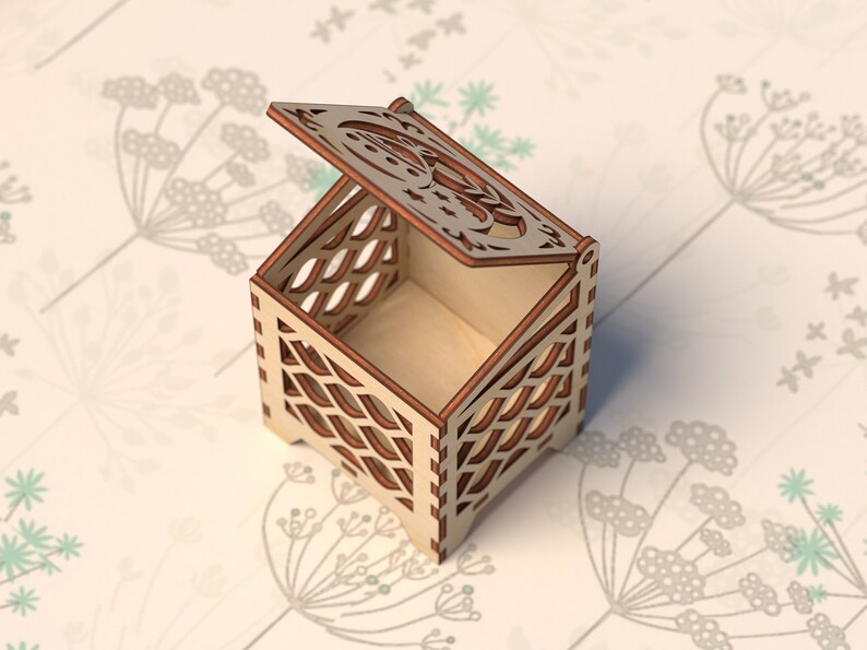 May include: A small wooden box with a decorative, open lid. The box is made of light wood with a brown stain and has a geometric pattern cut into the sides. The box is sitting on a white background.