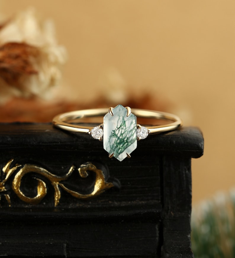 Pu&ograve; includere: Un anello d'oro con una pietra preziosa in agata verde e bianca e due piccoli diamanti sulla fascia.
