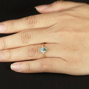 Pu&ograve; includere: Un anello d'oro con una pietra di agata verde e bianca e due piccoli diamanti sulla fascia.