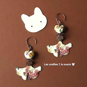 Könnte beinhalten: Handgefertigte Ohrringe mit floralem Design. Die Ohrringe haben eine herzförmige Perle, einen Kleeblatt-Charm und einen fächerförmigen Anhänger mit einem Blumenmuster in Rot-, Lila- und Grüntönen. Der Text lautet 'Les oreilles 2 la souris'.