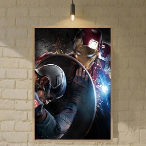 May include: Framed print featuring Iron Man and Captain America. Iron Man, in a red and gold suit, is positioned behind Captain America, who is holding his shield. The artwork has a dark, action-oriented theme.