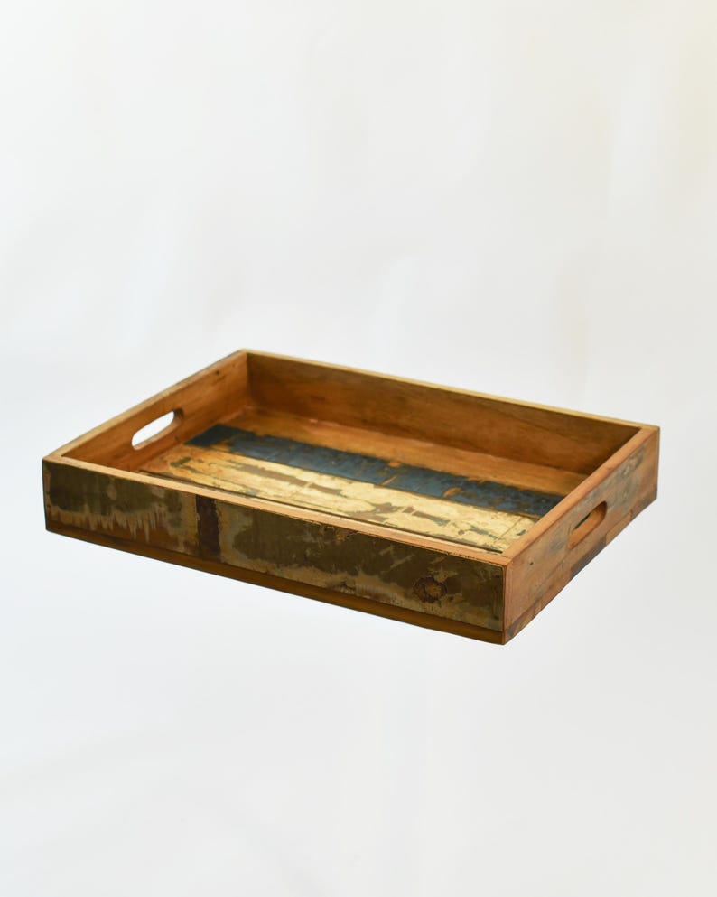 May include: Rectangular wooden serving tray with cut-out handles. The tray features a distressed finish with shades of brown, blue, and gold. The tray is empty and sits on a white background.